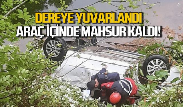 Dereye yuvarlanan aracın içinde mahsur kaldı!