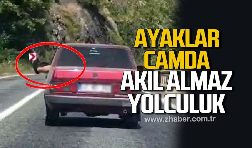 Ayaklarını camdan sarkıtarak trafiği tehlikeye attı